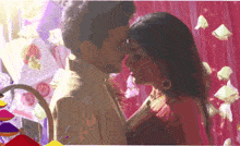 a man and a woman are kissing in front of a colorful background