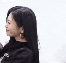 a woman wearing hoop earrings and a black shirt