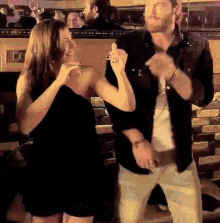 a man and a woman are dancing together at a party
