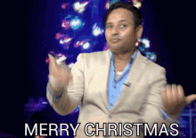 a man in a suit and blue shirt says merry christmas