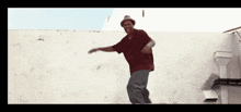 a man in a red shirt and hat is dancing