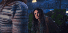 a woman with blue hair is standing next to another woman