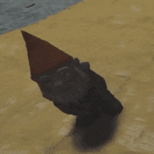 a gnome wearing a red hat is crawling on the floor