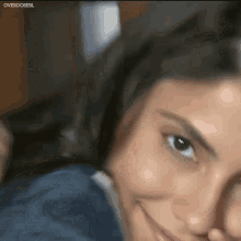 a close up of a woman 's face smiling and looking at the camera