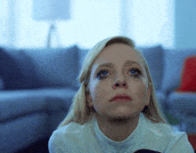 a woman with mascara on her eyes looks up at something