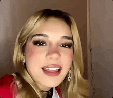 a close up of a woman 's face with her mouth open . she is wearing earrings and a choker .