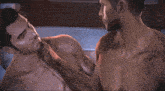 two shirtless men are kissing in a video game scene