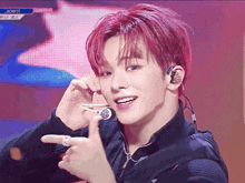 a young man with red hair is wearing headphones and a ring