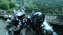 a transformer is fighting another transformer in front of a metal fence