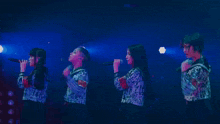 a group of girls singing into microphones with one wearing a shirt that says ' tokyo '