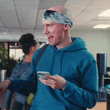 a bald man wearing a headband is looking at his cell phone