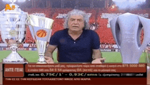 a man is holding a basketball trophy in front of a screen that says a6 on it
