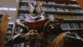 a statue of a superhero is sitting in front of a bookshelf