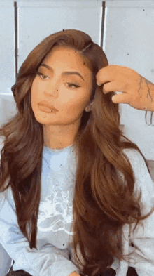 a woman with long brown hair is getting her hair done by a man