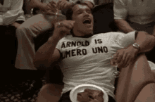 arnold schwarzenegger is wearing a t-shirt that says arnold is number uno