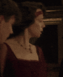 a man and a woman are standing next to each other and the woman is wearing a red dress .