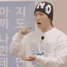 a man wearing a beanie and a sweatshirt that says dino