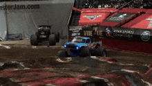 two monster jam trucks are racing in the dirt