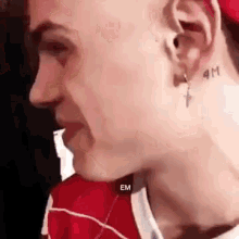 a close up of a man 's face with a tattoo on his ear .