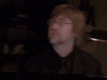 a man with glasses and a beard is looking up