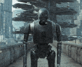 a robot with a helmet on stands on a bridge