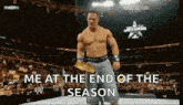 a man is holding a wrestling championship belt and says me at the end of the season .