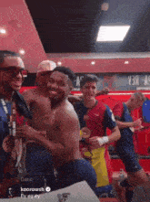 a group of men are posing for a photo in a locker room with a sign that says y3a-nc