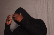 a person wearing a black hoodie is making a funny face