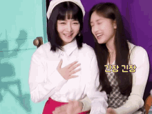 two girls are sitting next to each other and one has her hand on the other 's chest