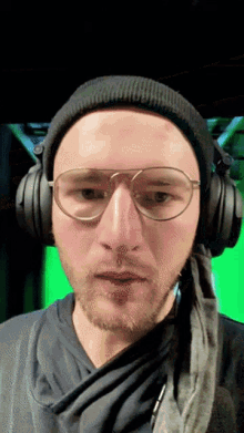 a man wearing headphones and glasses is making a face