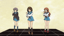 three anime girls are dancing together on a black tile floor