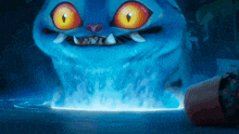 a blue monster with yellow eyes and sharp teeth is coming out of the water