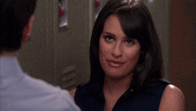 a woman in a blue shirt is smiling at a man in a blue shirt