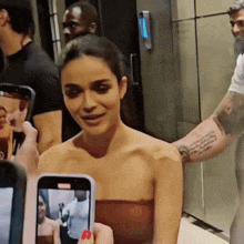 a woman with a bandage on her arm is being photographed by a man
