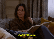 a woman sits on a couch reading a book and says " got it " course