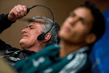 a man wearing a headset with the word adidas on the front of his shirt