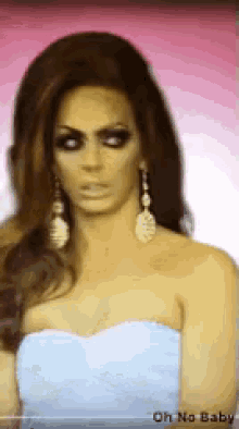 a woman wearing a white strapless dress and earrings with the words oh no baby on the bottom