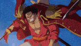 a man in a red shirt and straw hat is holding a sword in his right hand