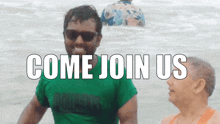 a man in a green shirt stands in the water with the words come join us behind him