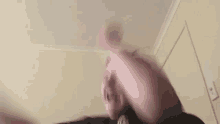 a blurry picture of a man standing in a room with a door in the background .