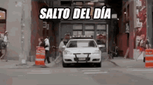 a white police car is driving down a street with the words salto del dia written on the bottom