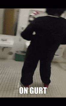 a person is standing in a bathroom with the words on gurt written on the floor