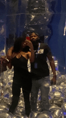 a man and a woman are taking a selfie in a room with balloons