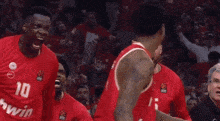 a group of basketball players wearing red jerseys with the number 25 on them