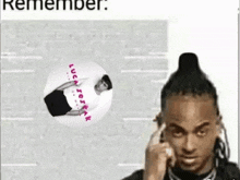 a man with dreadlocks is talking on a cell phone in front of a brick wall .