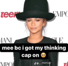 a woman wearing a black hat and a black jacket is standing in front of a white background .