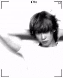 a black and white photo of a young man in a white t-shirt .