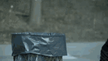 a person is throwing something in a trash can