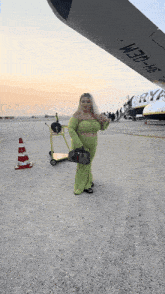 a woman in a green dress is standing in front of a plane that says ryanair on the side