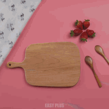 a person is cutting strawberries on a cutting board that says easy plus on the bottom